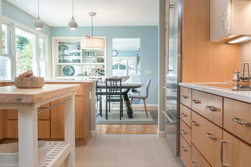 Mid-sized transitional l-shaped ceramic tile and beige floor eat-in kitchen photo with an undermount sink, flat-panel cabinets, white cabinets, granite countertops, beige backsplash, ceramic backsplash, stainless steel appliances and a peninsula