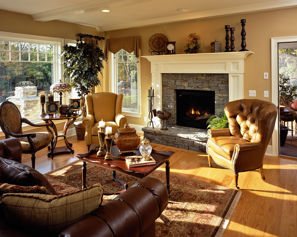 Photo of a traditional family room in New York with beige walls, medium hardwood floors, a standard fireplace, a stone fireplace surround and no tv.