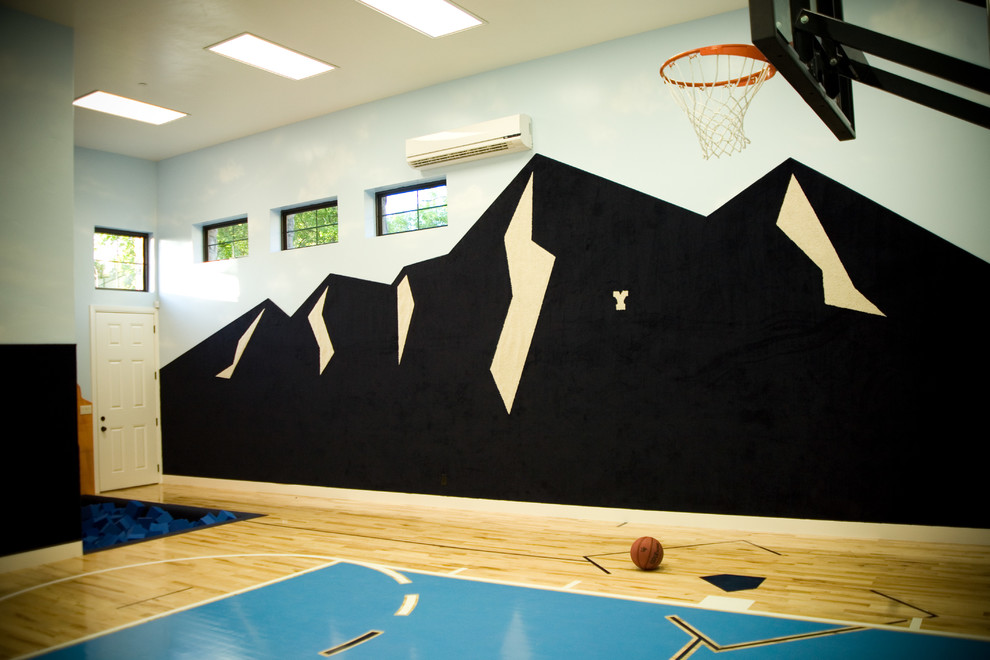 Large transitional indoor sport court in Salt Lake City with multi-coloured walls and plywood floors.