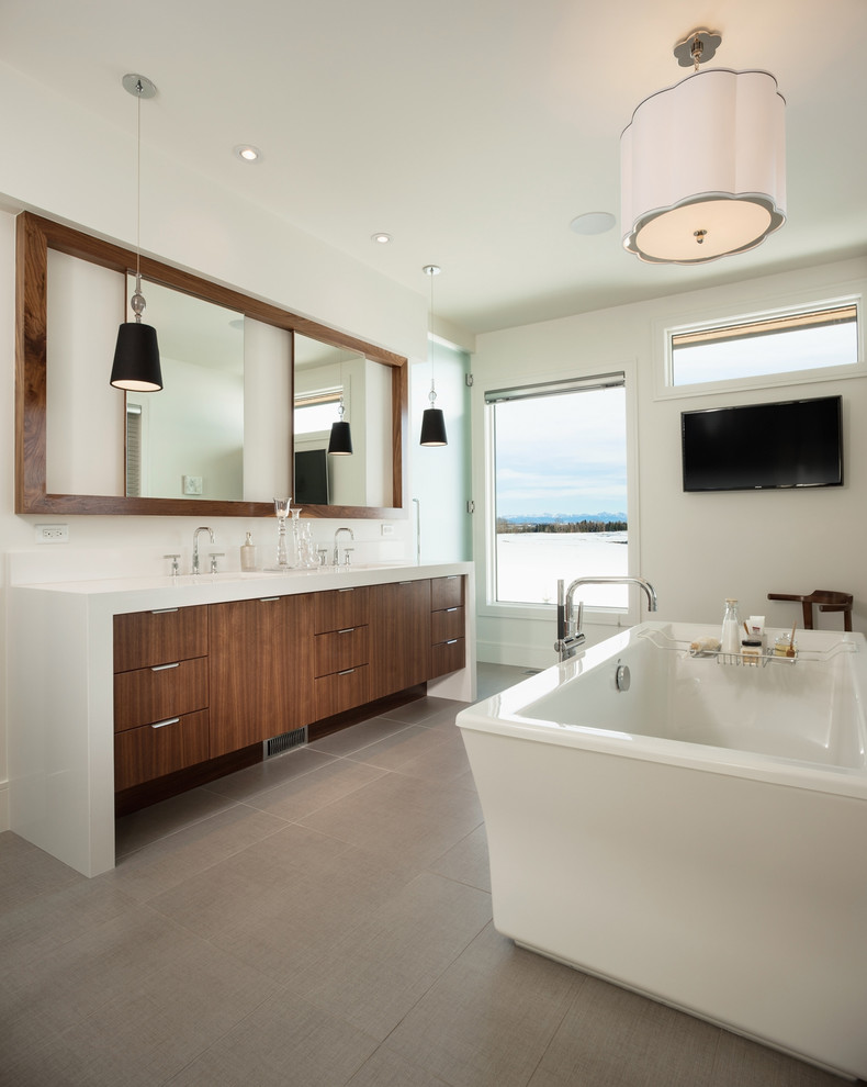 Inspiration for a large contemporary master bathroom in Calgary with flat-panel cabinets, medium wood cabinets, a freestanding tub, white walls, an undermount sink, engineered quartz benchtops, ceramic floors, grey floor and white benchtops.