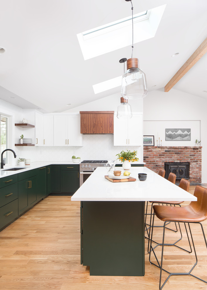 Design ideas for a mid-sized transitional l-shaped kitchen in Seattle with an undermount sink, recessed-panel cabinets, green cabinets, quartz benchtops, white splashback, ceramic splashback, stainless steel appliances, medium hardwood floors, with island and brown floor.