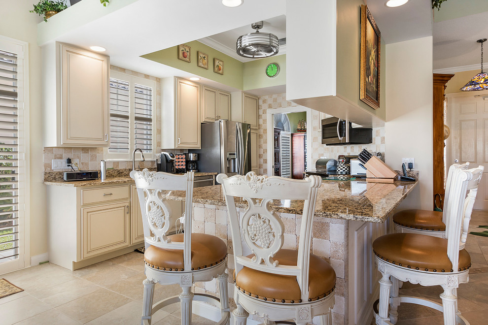 Example of a mid-sized transitional u-shaped porcelain tile and beige floor eat-in kitchen design in Miami with raised-panel cabinets, granite countertops, stone tile backsplash, stainless steel appliances, an undermount sink, beige cabinets, multicolored backsplash, a peninsula and multicolored countertops