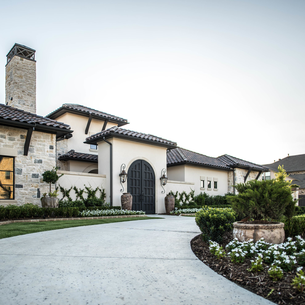 This is an example of a mediterranean full sun concrete paver driveway in Dallas.