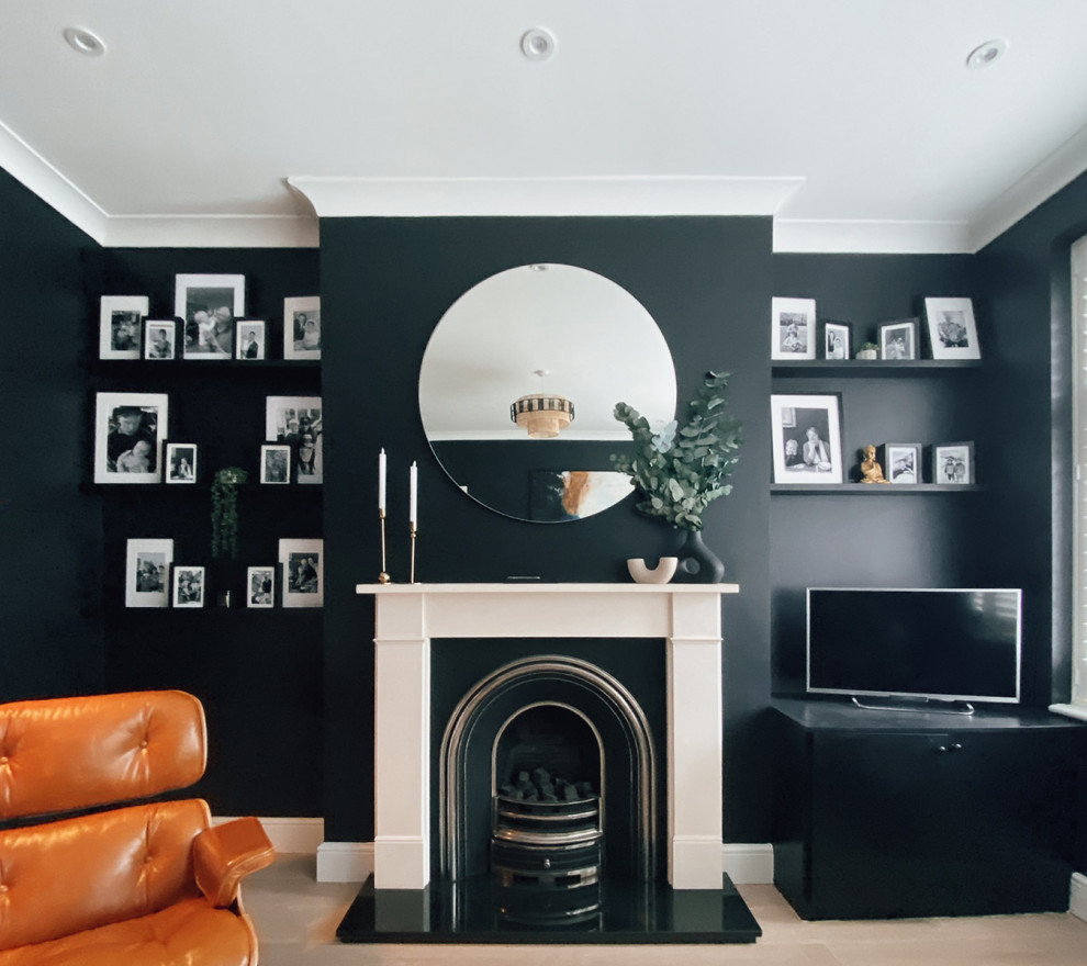 Idées déco pour un salon éclectique de taille moyenne et fermé avec un mur noir, un sol en bois brun, une cheminée standard, un manteau de cheminée en pierre, un téléviseur indépendant et un sol gris.
