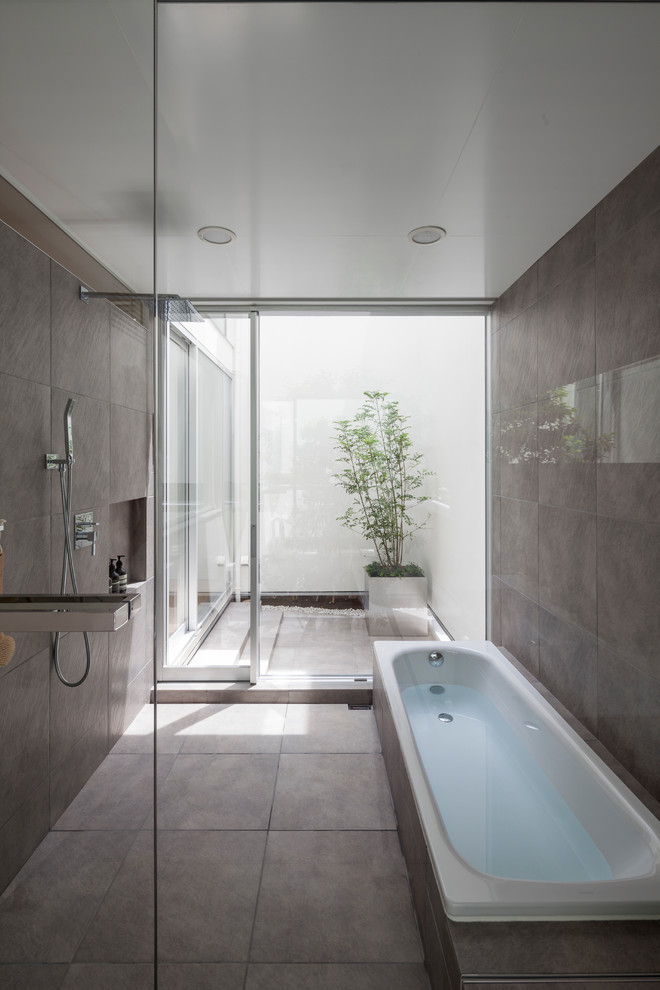 Inspiration for an industrial bathroom in Other with a corner tub, an open shower, grey walls, grey floor and an open shower.