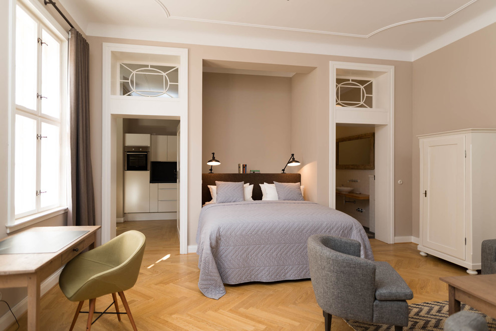 Expansive transitional bedroom in Berlin with beige walls, medium hardwood floors, no fireplace and brown floor.
