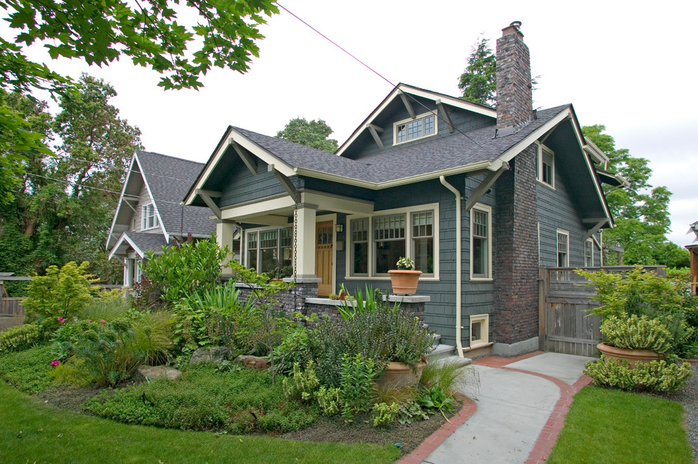 This is an example of a mid-sized arts and crafts two-storey blue house exterior in Seattle with wood siding and a shingle roof.