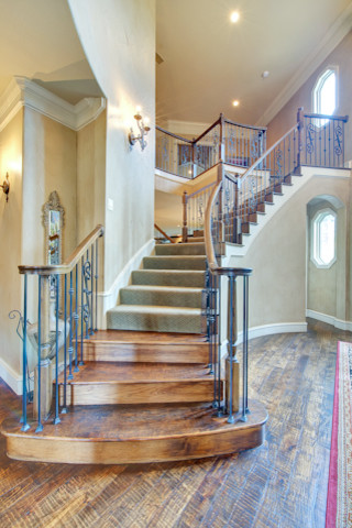 Design ideas for an expansive traditional carpeted curved staircase in Dallas with carpet risers.