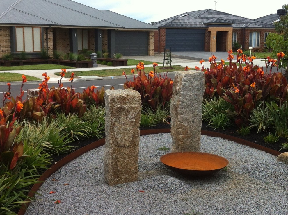 Inspiration for a mid-sized eclectic front yard full sun driveway in Melbourne with a fire feature and gravel.