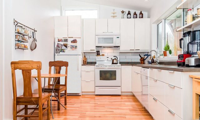 Design ideas for a small eclectic l-shaped eat-in kitchen in Vancouver with flat-panel cabinets, white cabinets, white splashback and no island.