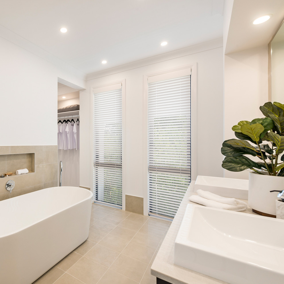 Photo of a large contemporary master bathroom in Canberra - Queanbeyan with shaker cabinets, white cabinets, a freestanding tub, white walls, ceramic floors, engineered quartz benchtops and beige floor.