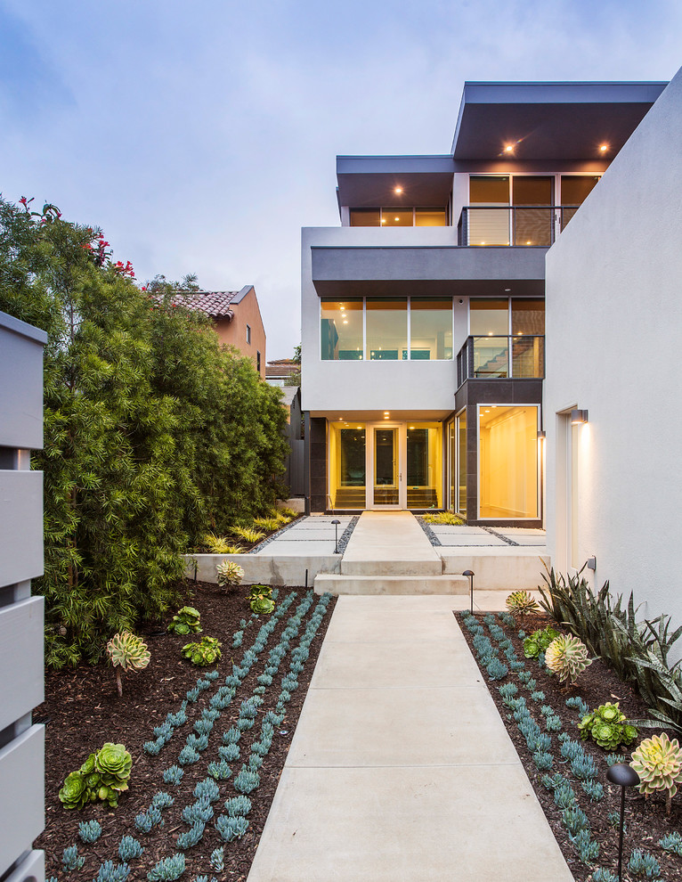 Photo of a large contemporary three-storey stucco grey house exterior in San Diego.