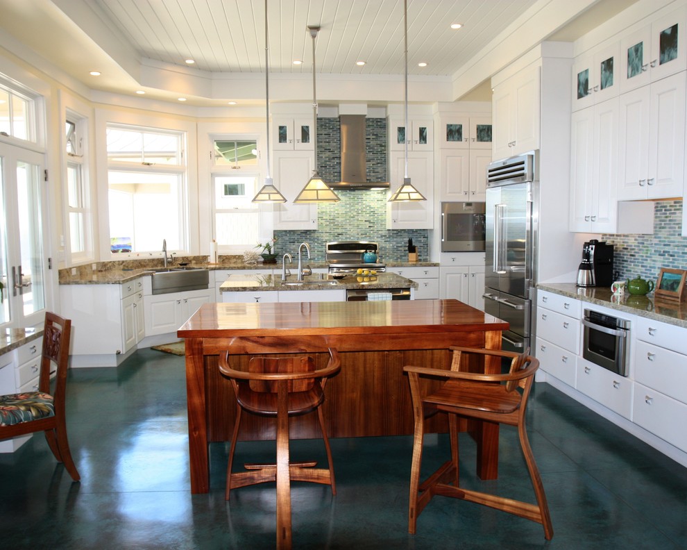 Inspiration for a large beach style kitchen in San Diego with a farmhouse sink, raised-panel cabinets, white cabinets, granite benchtops, blue splashback, glass tile splashback, stainless steel appliances, concrete floors, multiple islands, turquoise floor and multi-coloured benchtop.