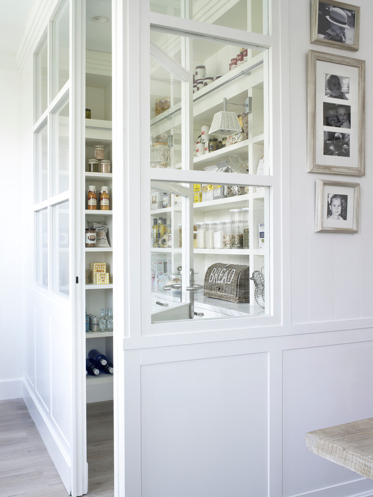 Photo of a mid-sized country l-shaped kitchen pantry in Barcelona with an undermount sink, white cabinets, marble benchtops, white splashback, stone slab splashback, white appliances, light hardwood floors and no island.