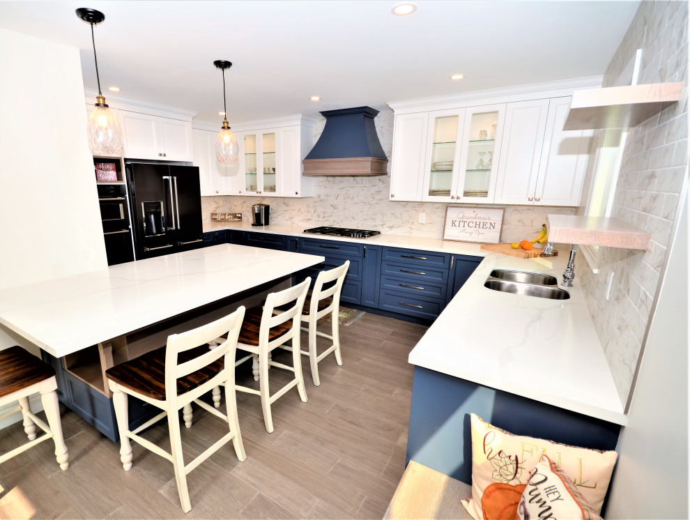 Eat-in kitchen - mid-sized transitional l-shaped laminate floor and brown floor eat-in kitchen idea in Toronto with an undermount sink, shaker cabinets, blue cabinets, quartz countertops, multicolored backsplash, subway tile backsplash, black appliances, an island and white countertops