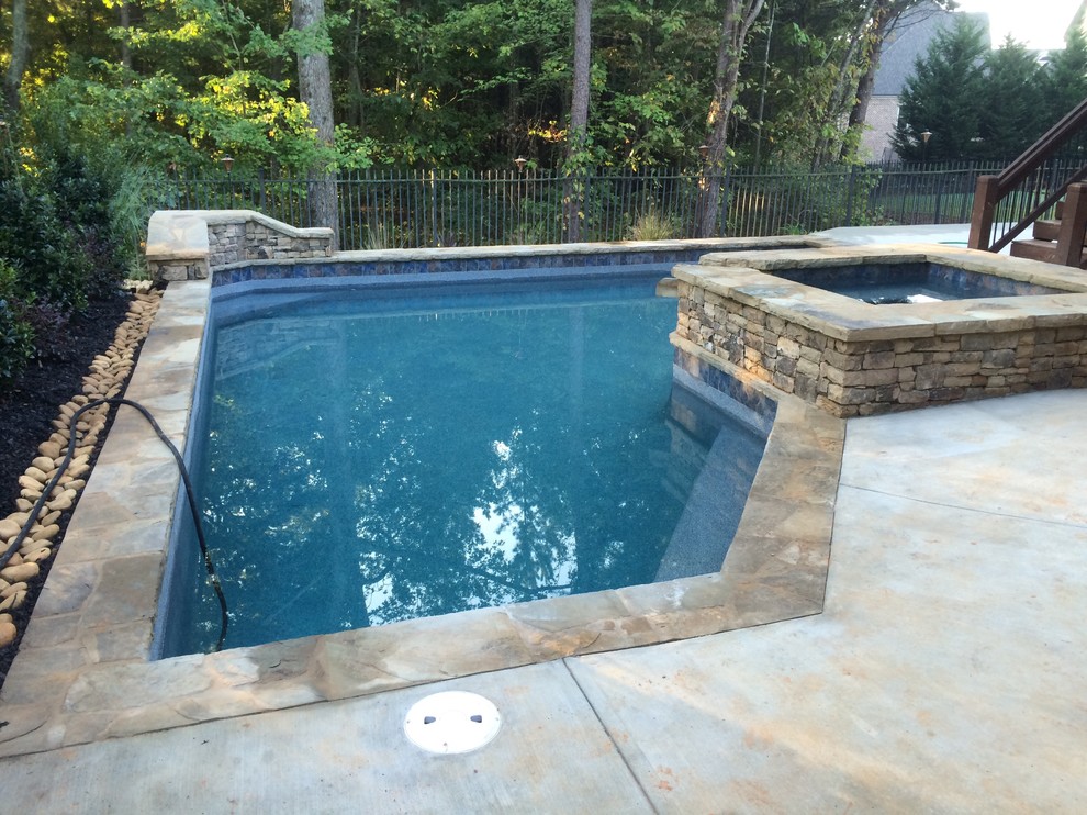 Photo of a small arts and crafts backyard custom-shaped natural pool in Atlanta with a hot tub and decking.