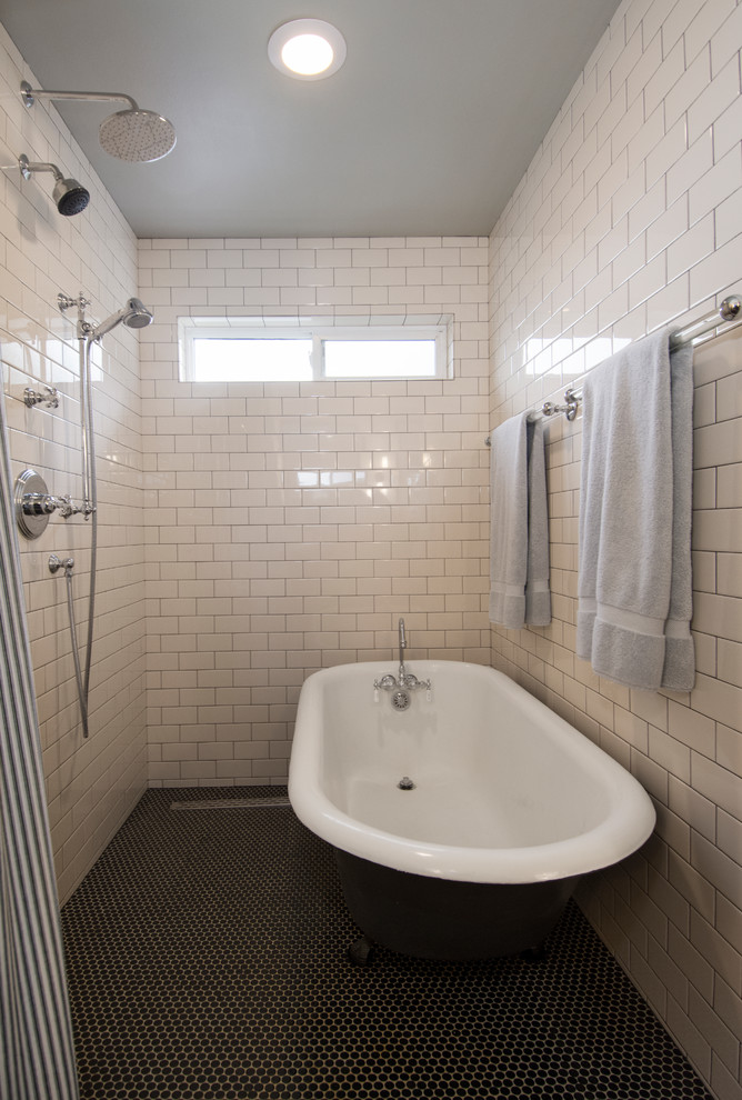 This is an example of a mid-sized traditional master wet room bathroom in Seattle with furniture-like cabinets, distressed cabinets, a claw-foot tub, a one-piece toilet, white tile, ceramic tile, grey walls, porcelain floors, an undermount sink, quartzite benchtops, black floor and a shower curtain.