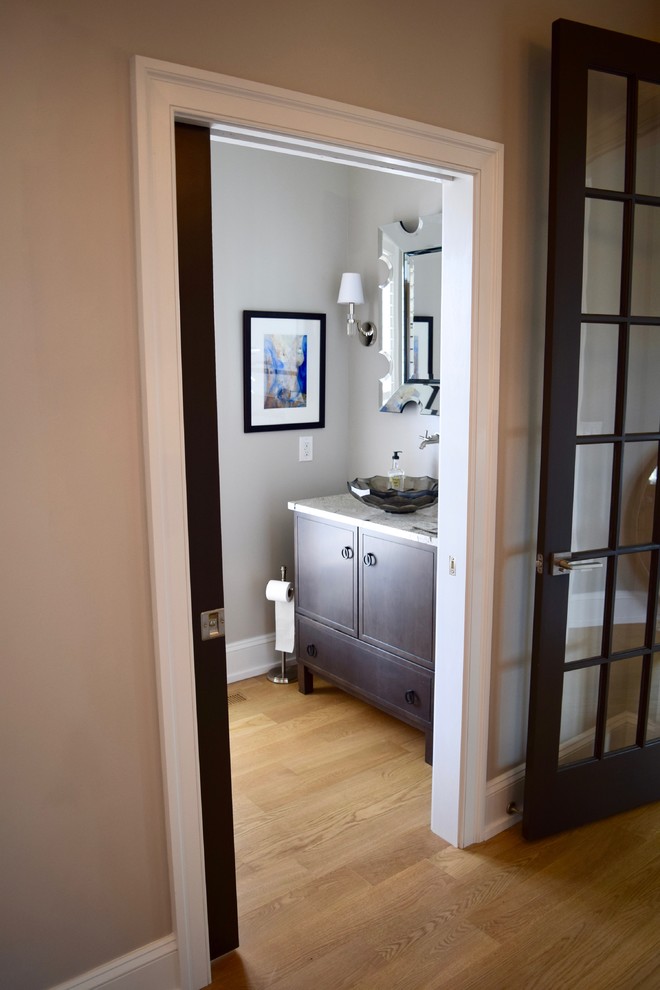 Design ideas for a small transitional powder room in Other with furniture-like cabinets, dark wood cabinets, grey walls, light hardwood floors, a vessel sink, beige floor and grey benchtops.
