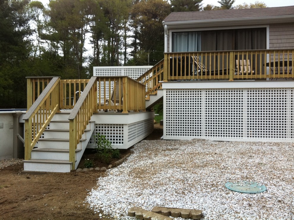 Example of a mid-sized backyard deck design in Boston with no cover