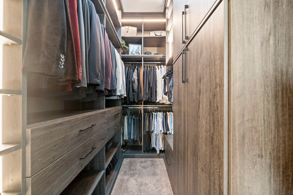 This is an example of a large modern gender-neutral walk-in wardrobe in Houston with light wood cabinets, carpet, grey floor and vaulted.