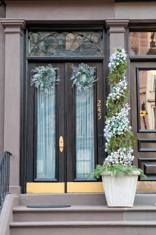 This is an example of a traditional entryway in Boston with a black front door.
