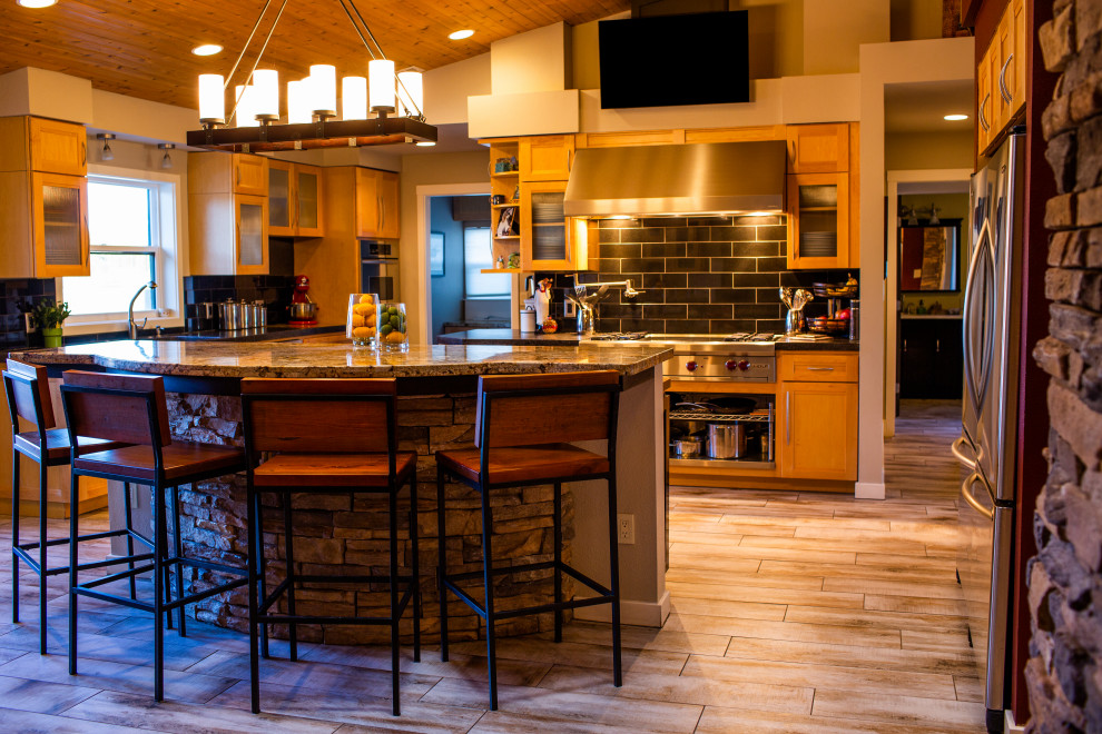 Inspiration for a large rustic l-shaped porcelain tile and beige floor open concept kitchen remodel in Phoenix with an undermount sink, recessed-panel cabinets, light wood cabinets, concrete countertops, black backsplash, ceramic backsplash, stainless steel appliances, an island and black countertops