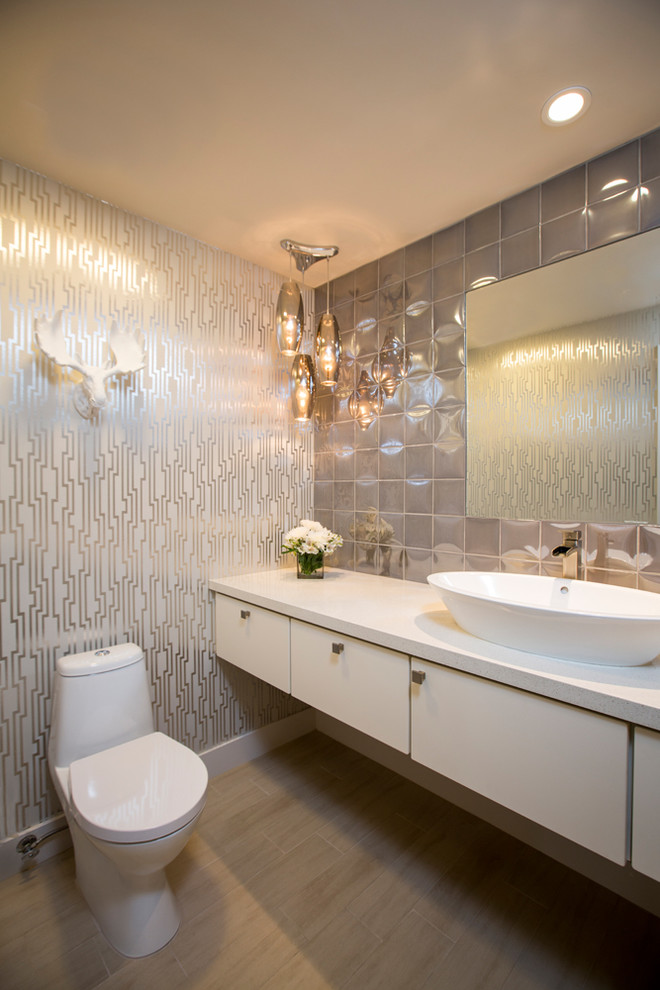 Design ideas for a contemporary powder room in Los Angeles with a vessel sink, flat-panel cabinets, white cabinets, multi-coloured walls, engineered quartz benchtops, gray tile, porcelain tile, porcelain floors and white benchtops.