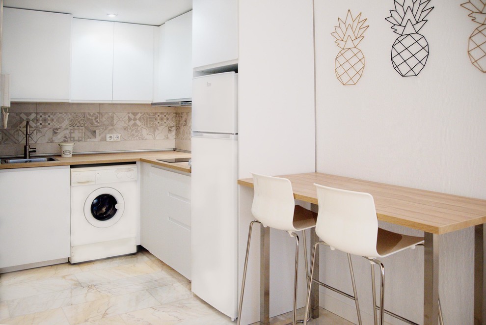 Inspiration for a small scandinavian l-shaped open plan kitchen in Madrid with a single-bowl sink, flat-panel cabinets, white cabinets, laminate benchtops, beige splashback, ceramic splashback, white appliances, marble floors, no island, white floor and brown benchtop.