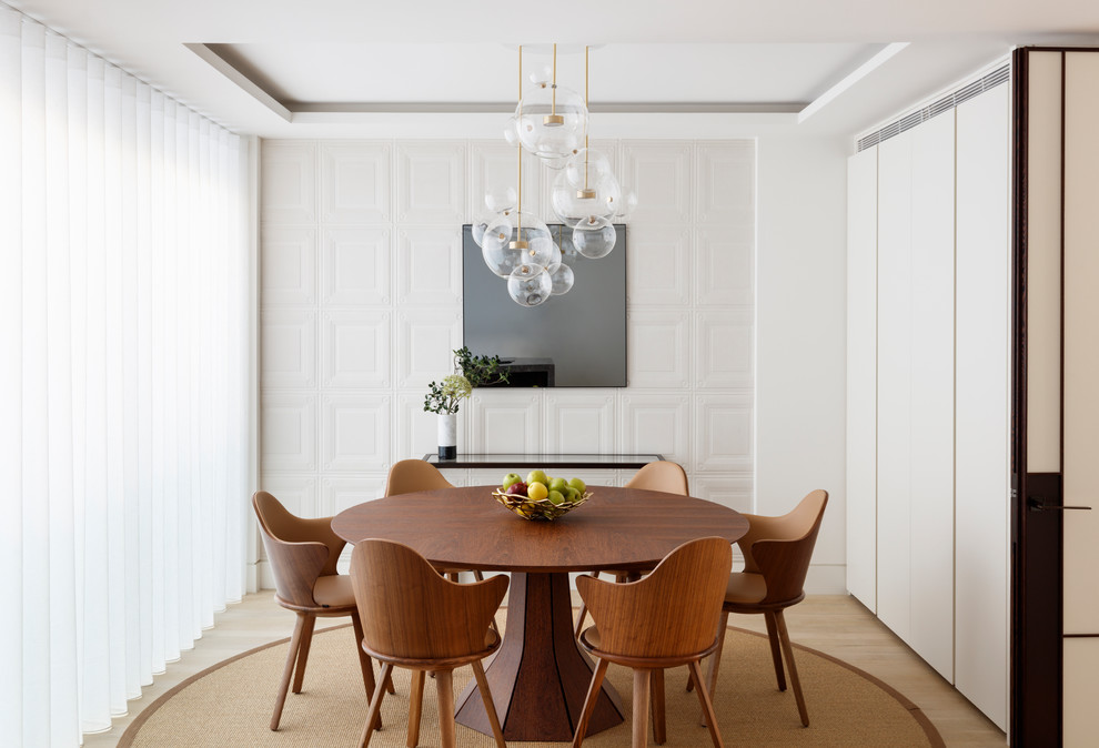 Transitional separate dining room in London with white walls and light hardwood floors.