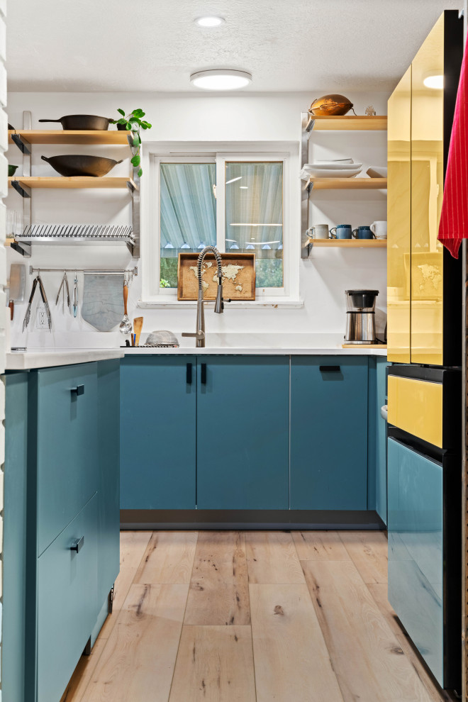 Foto di una piccola cucina eclettica chiusa con lavello da incasso, ante lisce, ante blu, top in marmo, paraspruzzi bianco, elettrodomestici colorati, pavimento in vinile, pavimento beige e top bianco