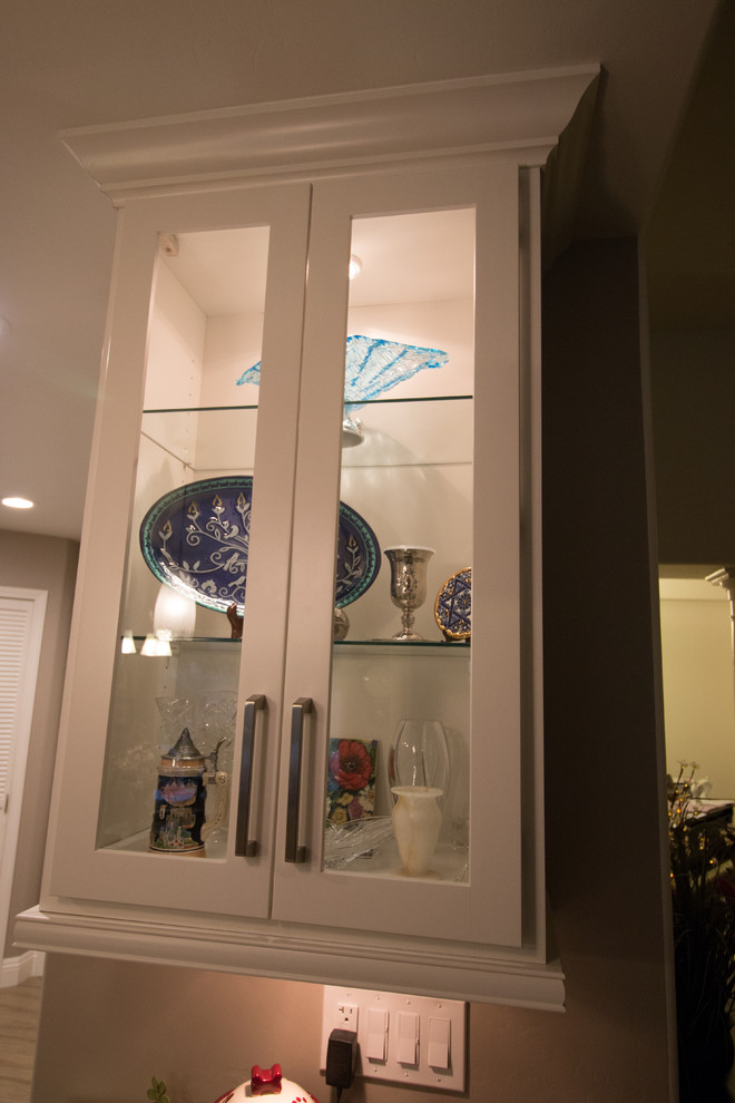 Open concept kitchen - mid-sized transitional galley porcelain tile open concept kitchen idea with a farmhouse sink, shaker cabinets, white cabinets, quartz countertops, white backsplash, subway tile backsplash and stainless steel appliances