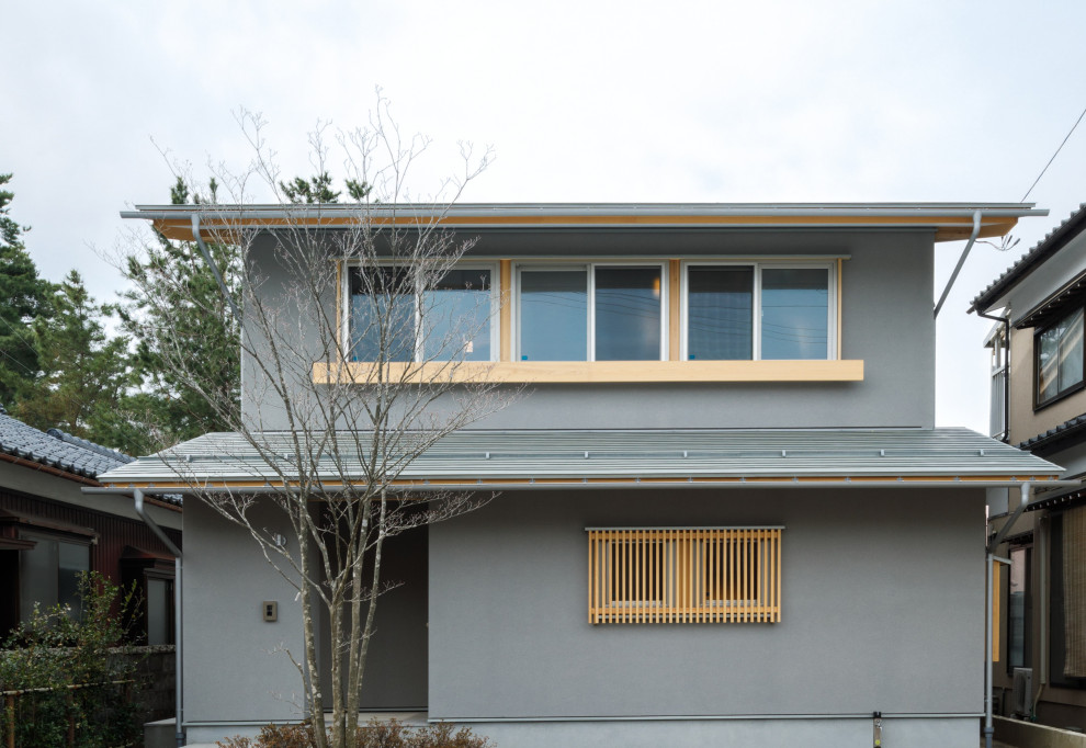 Inspiration pour une petite façade de maison grise asiatique à un étage avec un toit à deux pans, un toit en métal et un toit gris.