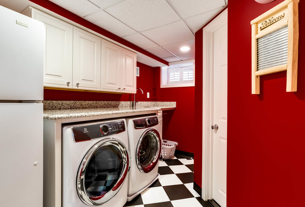 Small traditional galley dedicated laundry room in DC Metro with raised-panel cabinets, white cabinets, granite benchtops, red walls, ceramic floors, a side-by-side washer and dryer and white floor.