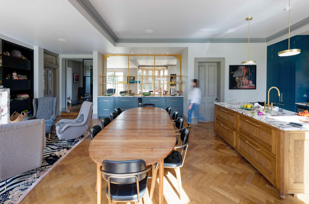 Foto di un'ampia sala da pranzo aperta verso il soggiorno minimalista con pareti beige, pavimento in legno massello medio, stufa a legna, cornice del camino in pietra e pavimento marrone