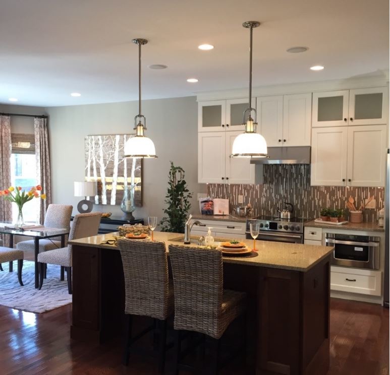 Transitional medium tone wood floor home design photo in Boston with an undermount sink, white cabinets, glass sheet backsplash and stainless steel appliances