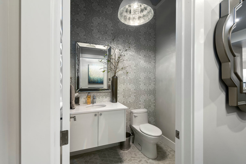 This is an example of a small transitional powder room in Other with an undermount sink, flat-panel cabinets, white cabinets, quartzite benchtops, a one-piece toilet, grey walls and porcelain floors.