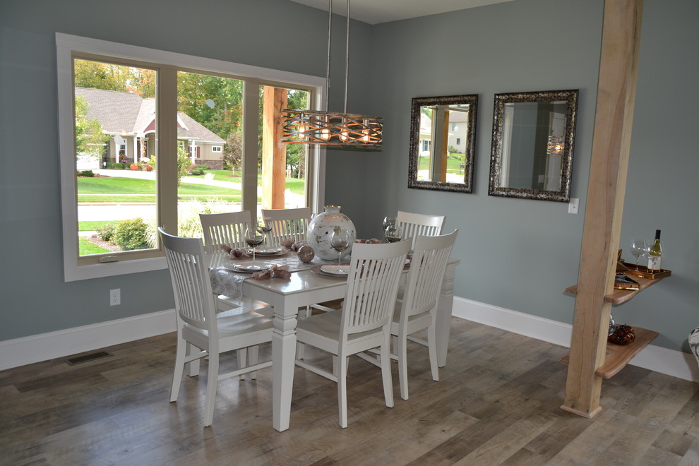 Design ideas for a mid-sized transitional open plan dining in Cleveland with grey walls, vinyl floors, a corner fireplace, a metal fireplace surround and beige floor.