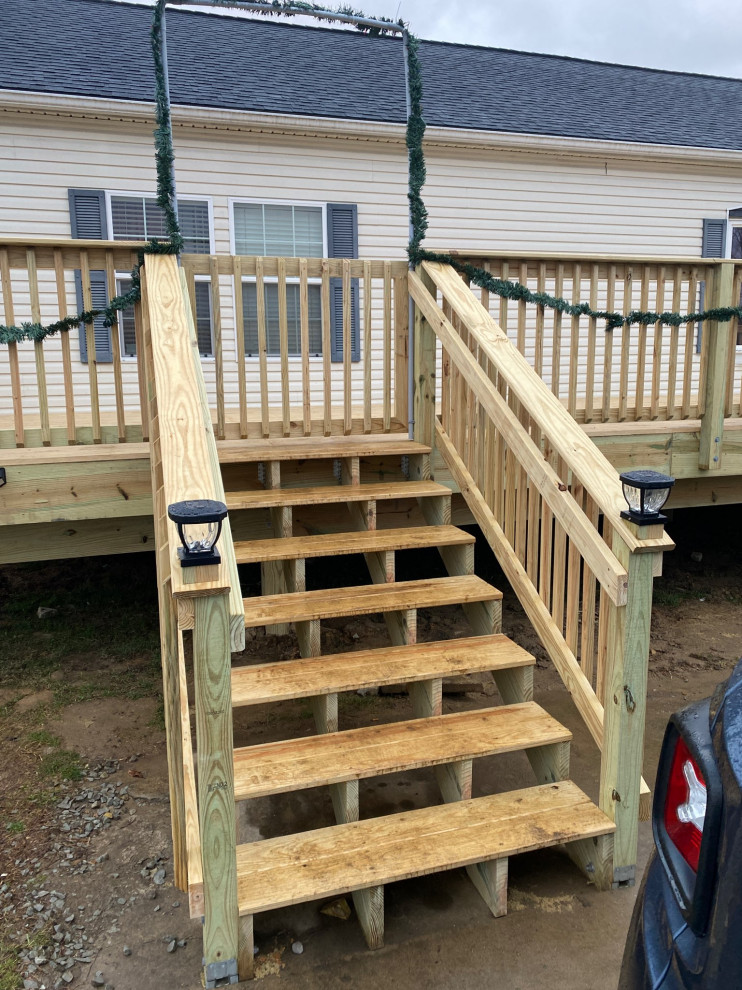 Deck - mid-sized rustic backyard ground level wood railing deck idea with no cover