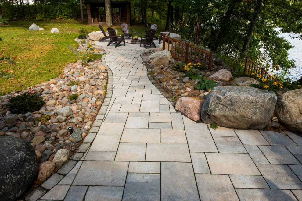 Mid-sized country backyard partial sun garden in Other with with path and concrete pavers.
