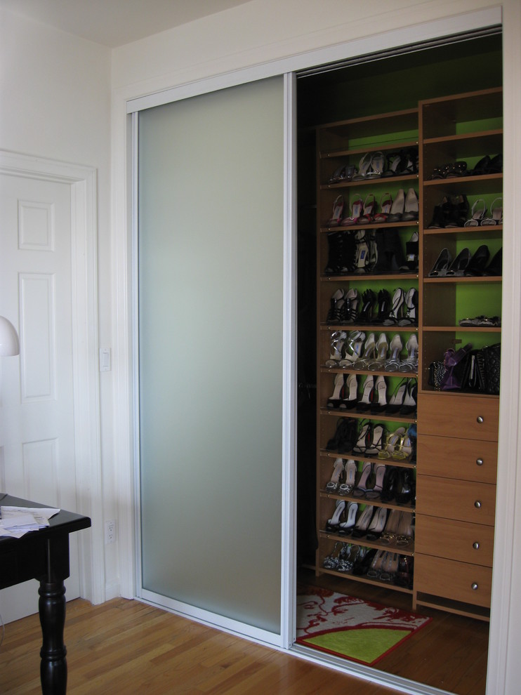Photo of a small eclectic women's walk-in wardrobe in Los Angeles with flat-panel cabinets, light wood cabinets, light hardwood floors and brown floor.