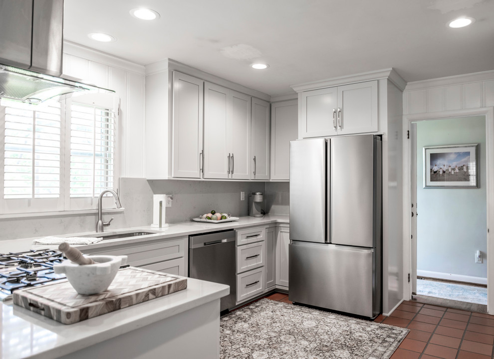 Cette photo montre une cuisine américaine tendance en U de taille moyenne avec un placard à porte shaker, des portes de placard blanches et un plan de travail blanc.