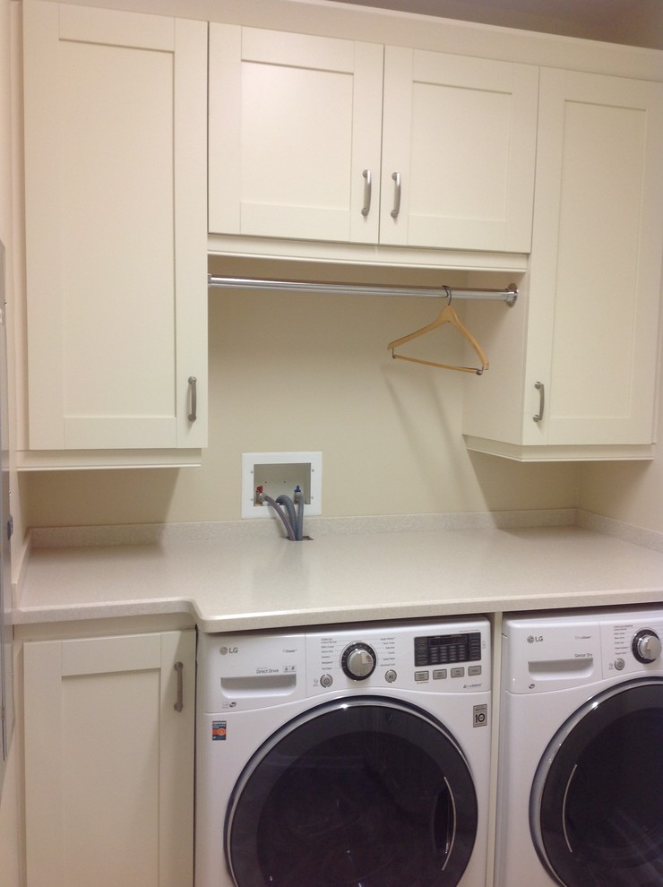 Transitional utility room in Chicago with flat-panel cabinets, beige cabinets, solid surface benchtops, beige walls and a side-by-side washer and dryer.