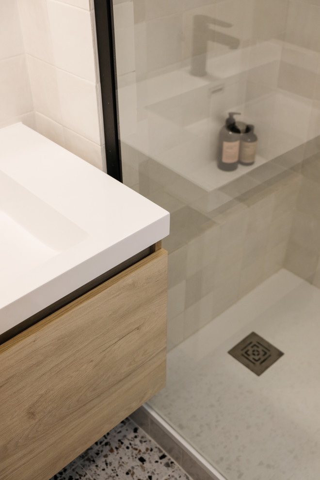Small modern 3/4 bathroom in Marseille with a curbless shower, a wall-mount toilet, white tile, white walls, terrazzo floors, a console sink, laminate benchtops, white benchtops, a shower seat and a single vanity.