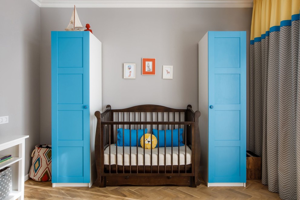 Inspiration for a mid-sized transitional nursery for boys in Other with grey walls, medium hardwood floors and brown floor.