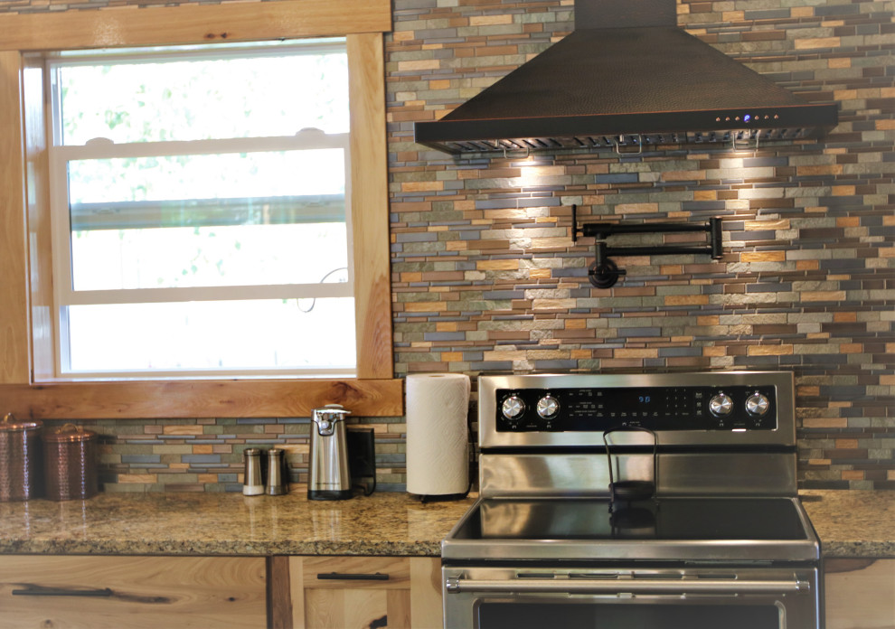 Example of a large mountain style kitchen design with granite countertops and stone tile backsplash