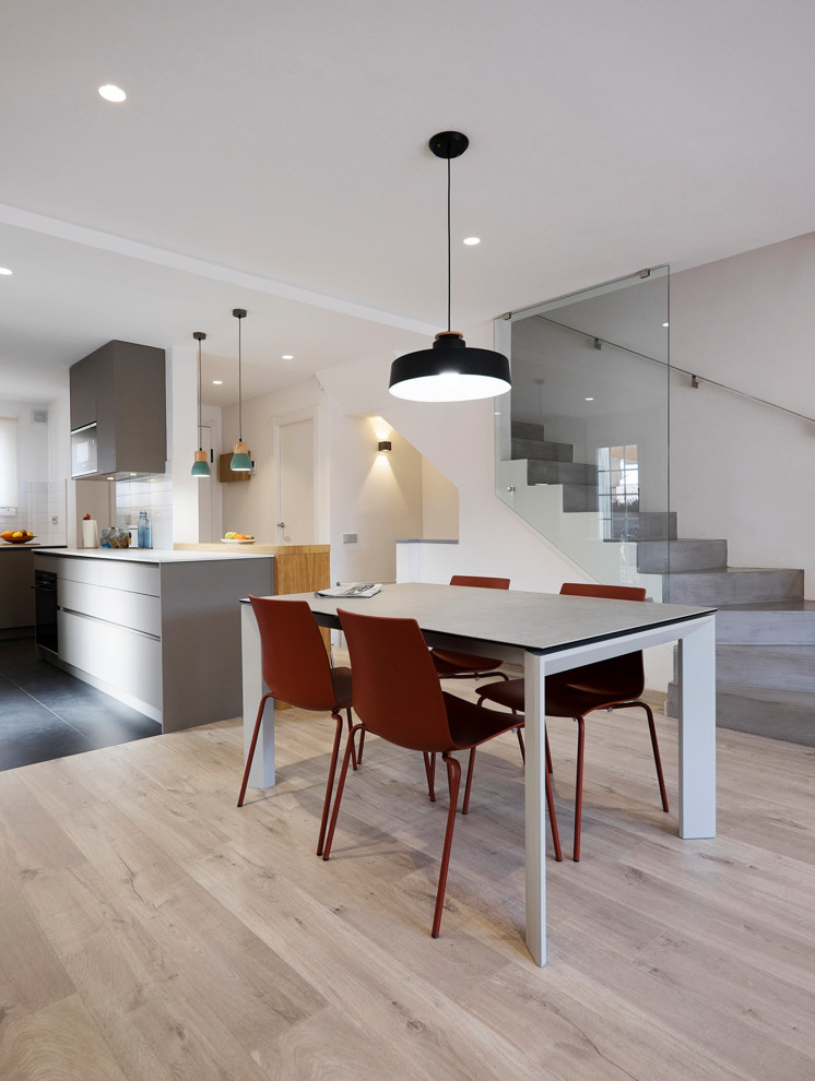 Foto de comedor moderno grande abierto con paredes blancas, suelo de madera en tonos medios y todas las chimeneas