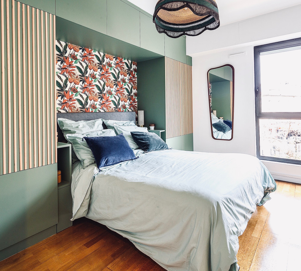 Esempio di una camera matrimoniale stile shabby di medie dimensioni con pareti verdi, pavimento in laminato, pavimento marrone, soffitto in legno e carta da parati
