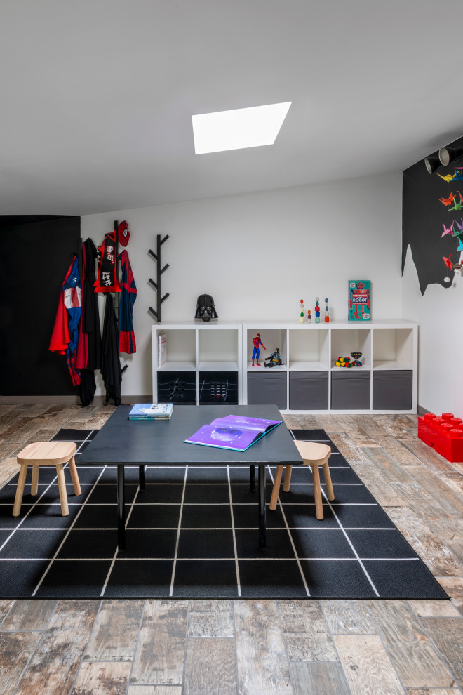 Immagine di una piccola e In mansarda cameretta per bambini moderna con pareti bianche, pavimento in gres porcellanato e pavimento marrone