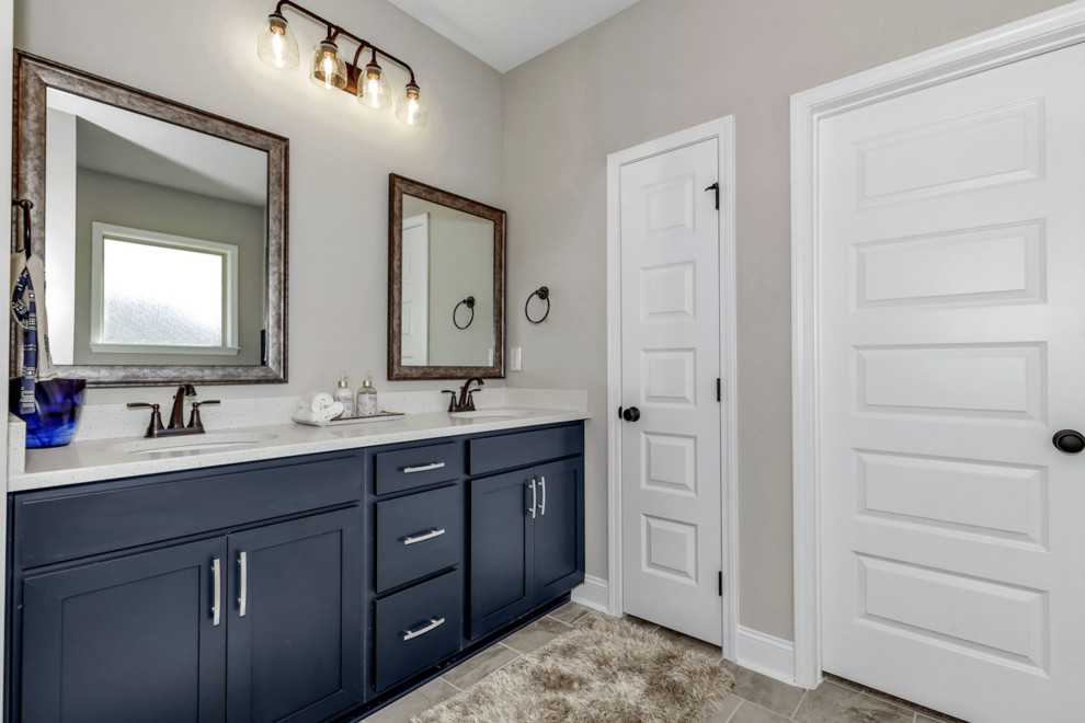Aménagement d'une salle de bain principale classique de taille moyenne avec des portes de placard bleues, un mur gris, un sol en carrelage de céramique, un plan de toilette en granite, un sol multicolore, un plan de toilette blanc, des toilettes cachées, meuble double vasque et meuble-lavabo encastré.