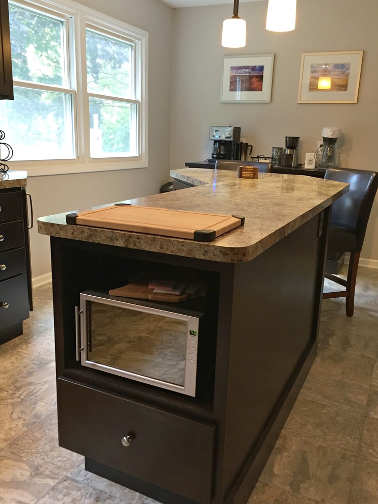 Inspiration for a mid-sized transitional l-shaped limestone floor open concept kitchen remodel with a drop-in sink, shaker cabinets, dark wood cabinets, granite countertops, stainless steel appliances and an island